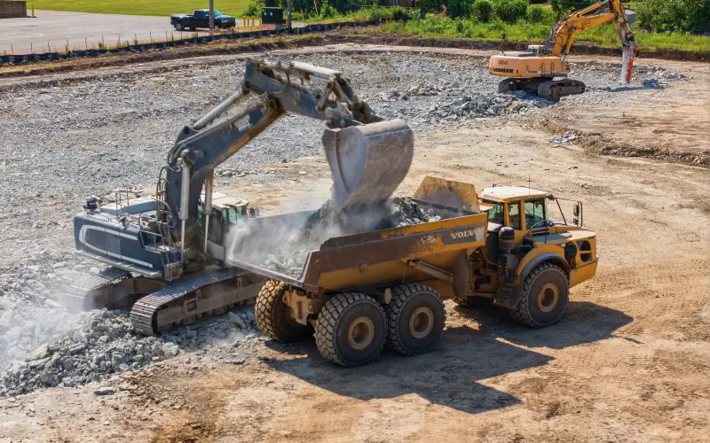 Equipment loading rock during visible site-preparation work at South Coast on July 29, 2026